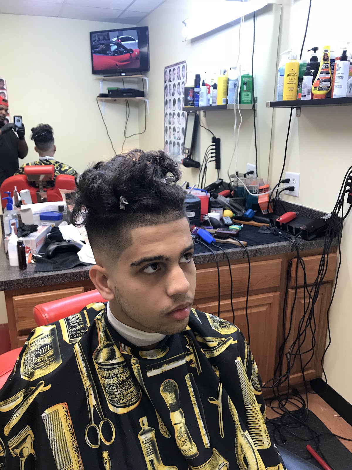 Curly top with a clean taper fade, finished at TAY'S Cut Above The Rest