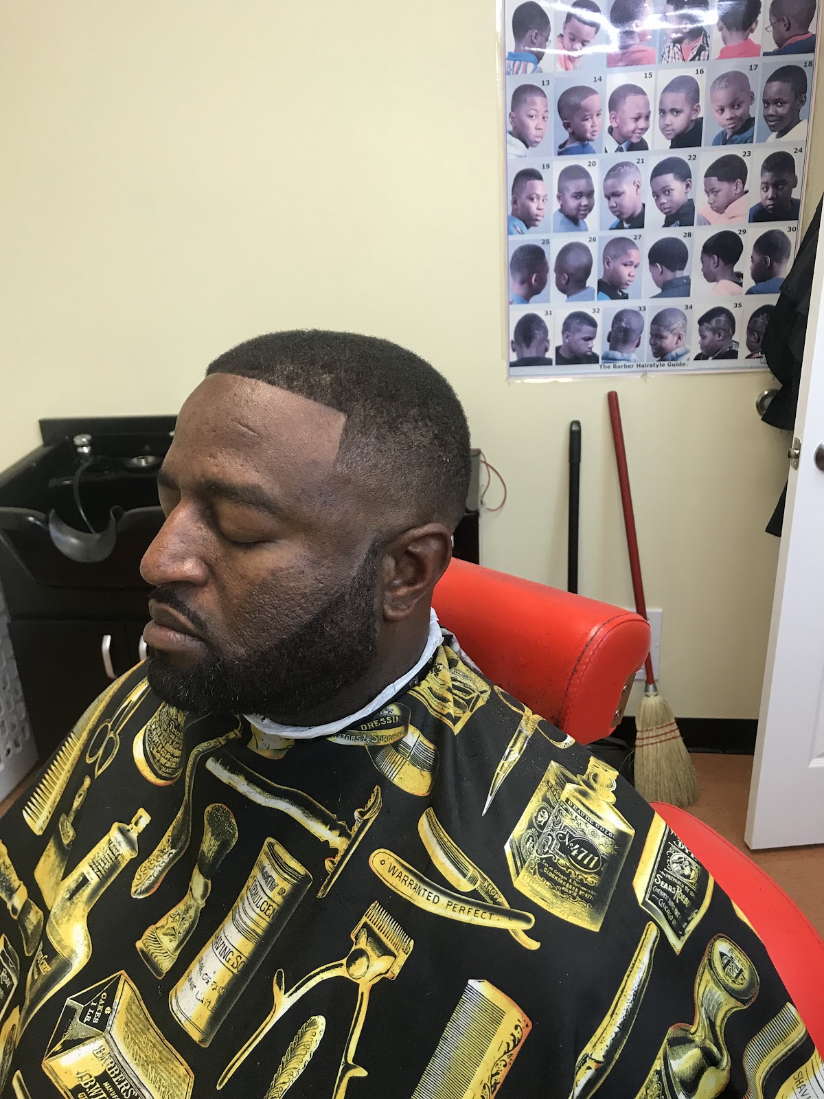 Sharp fade and lined-up beard, client reclined in the barber chair