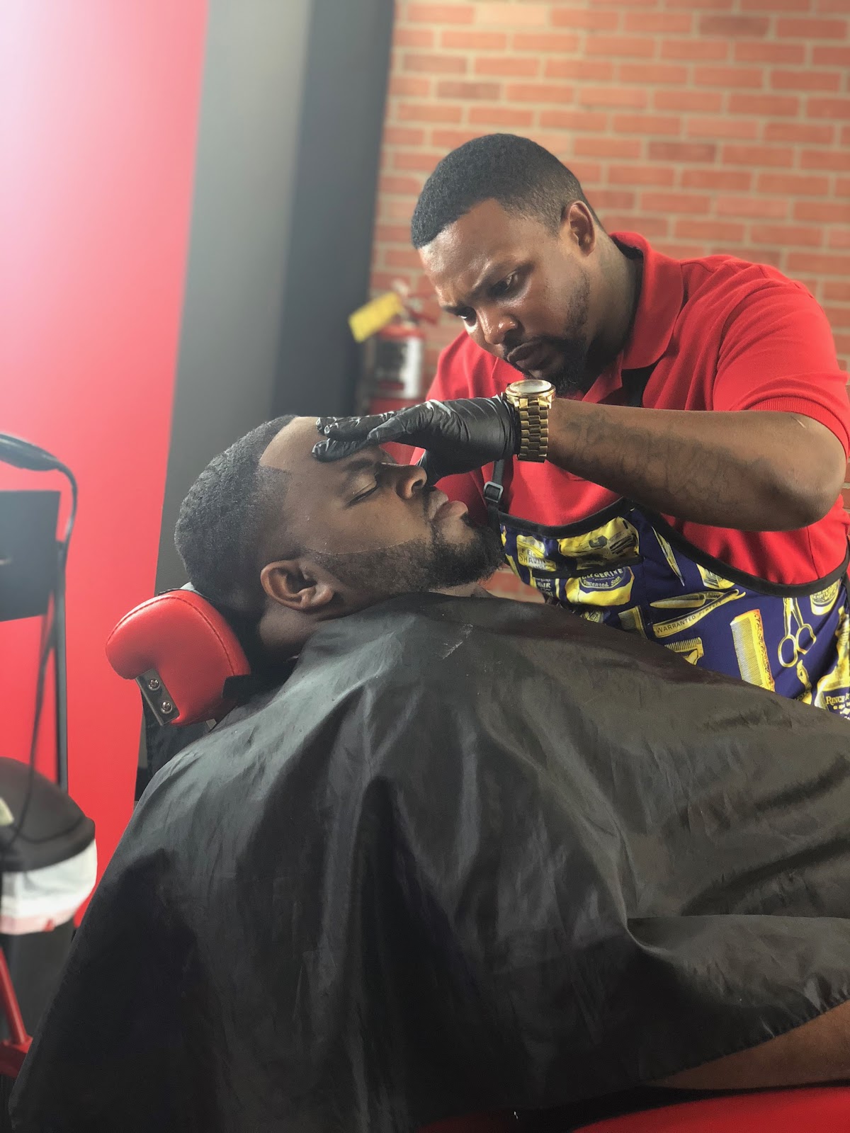 Tay lining up a client's beard with precision at TAY'S Cut Above The Rest Barbershop in Stockbridge, GA